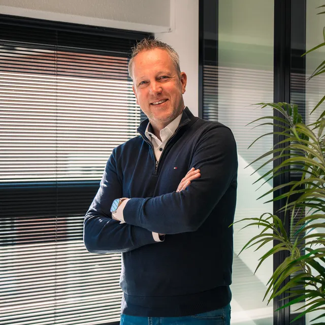 man aan het lachen naar de camera in een kantoorruimte