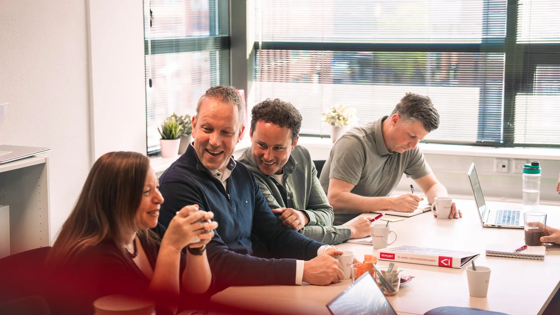 groep collega's aan het lachen tijdens een vergadering