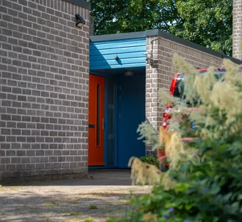 sfeerafbeelding van een huis met oranje deur en blauw kozijn