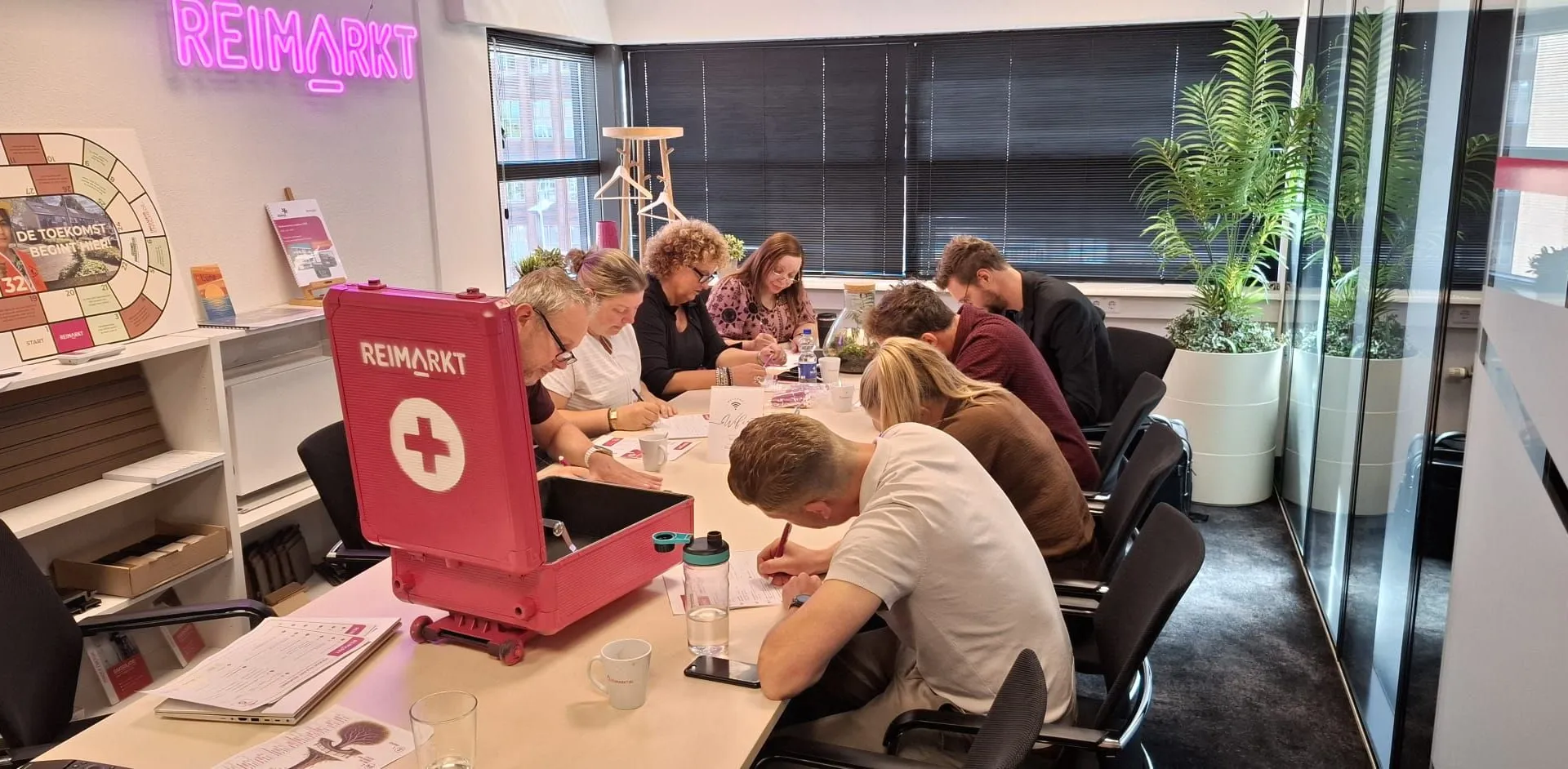 Het team werkt in het kantoor van Reimarkt aan tafel