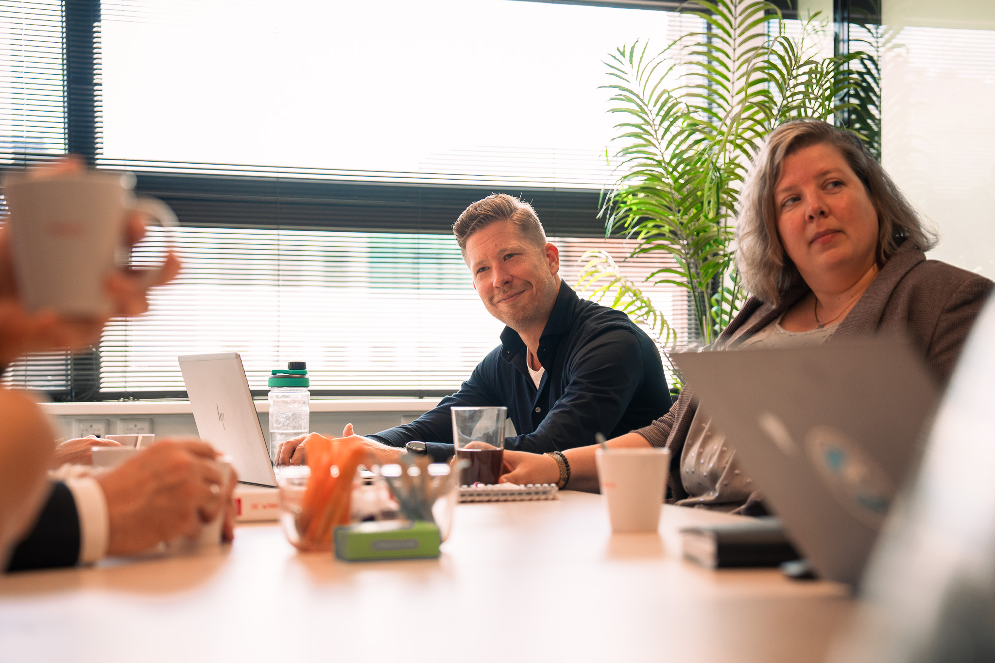 overlegsituatie aan een vergadertafel tussen een man en vrouw