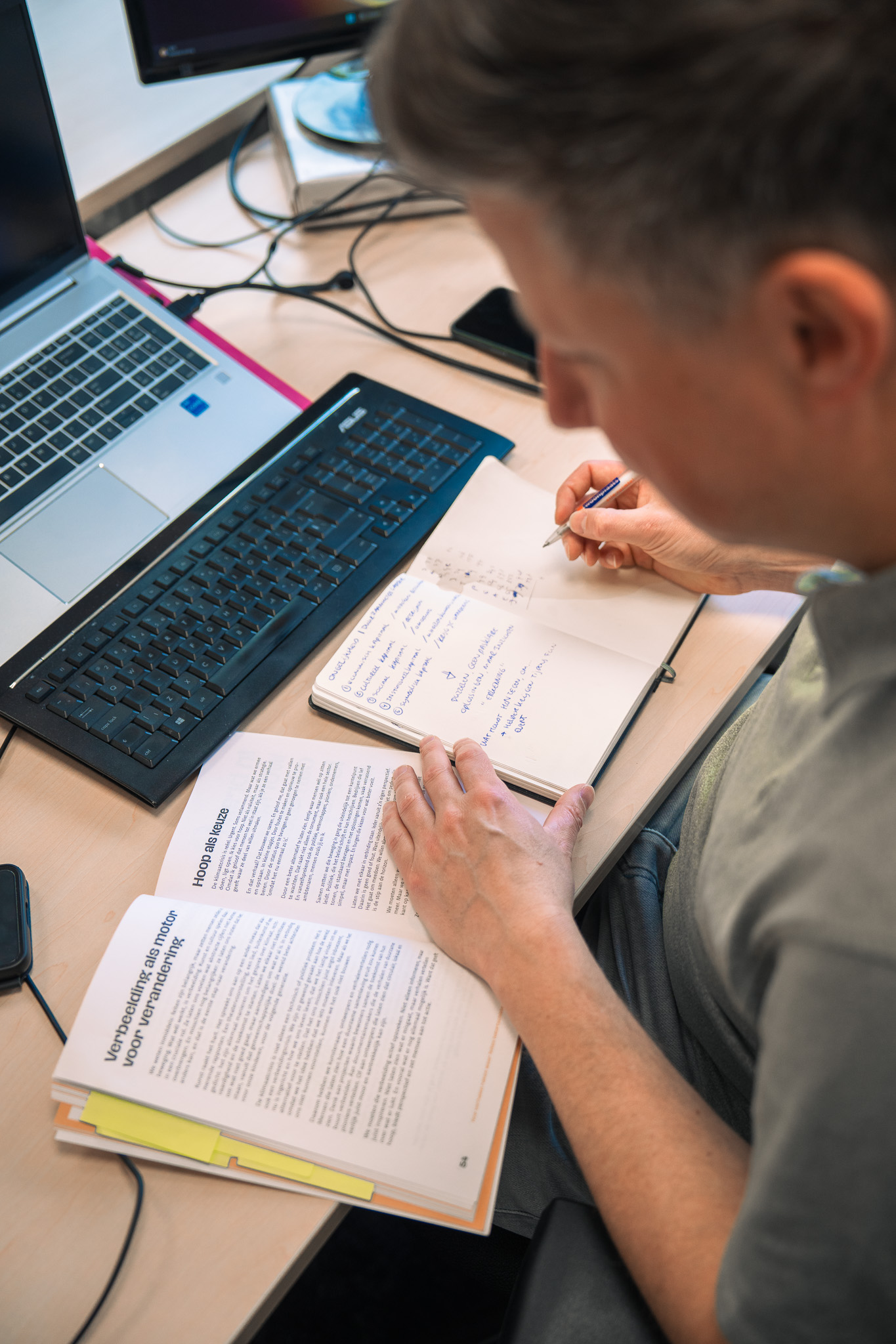 man geconcentreerd aan het werk in zijn notitieblok