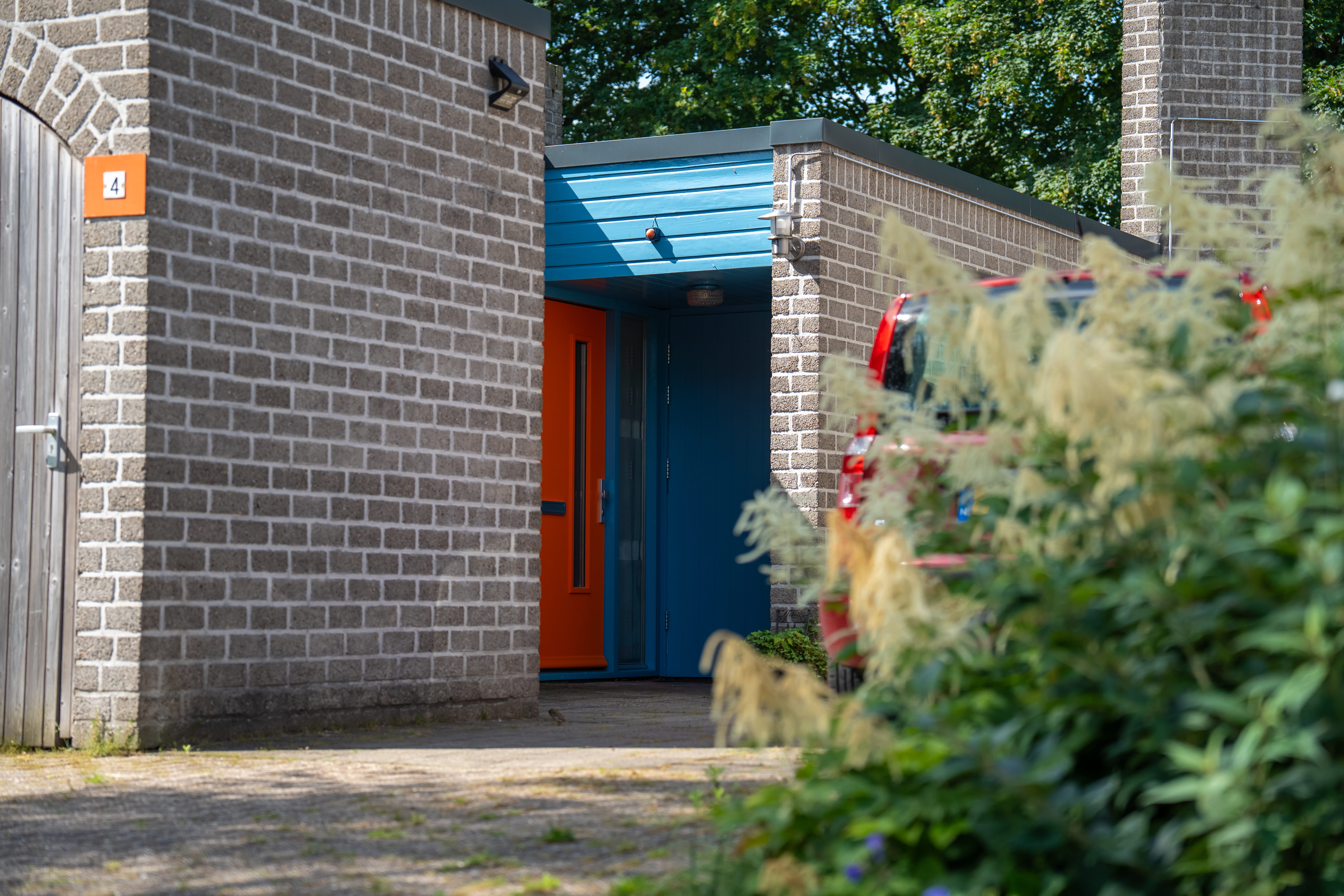 sfeerafbeelding van een huis met oranje deur en blauw kozijn